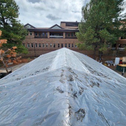 Applying tarp to the RETF roof prior to work
